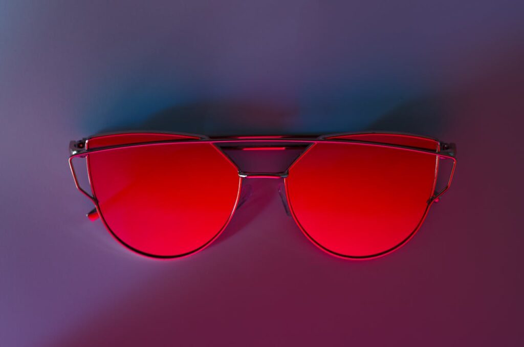 Red Sunglasses on Pink Surface